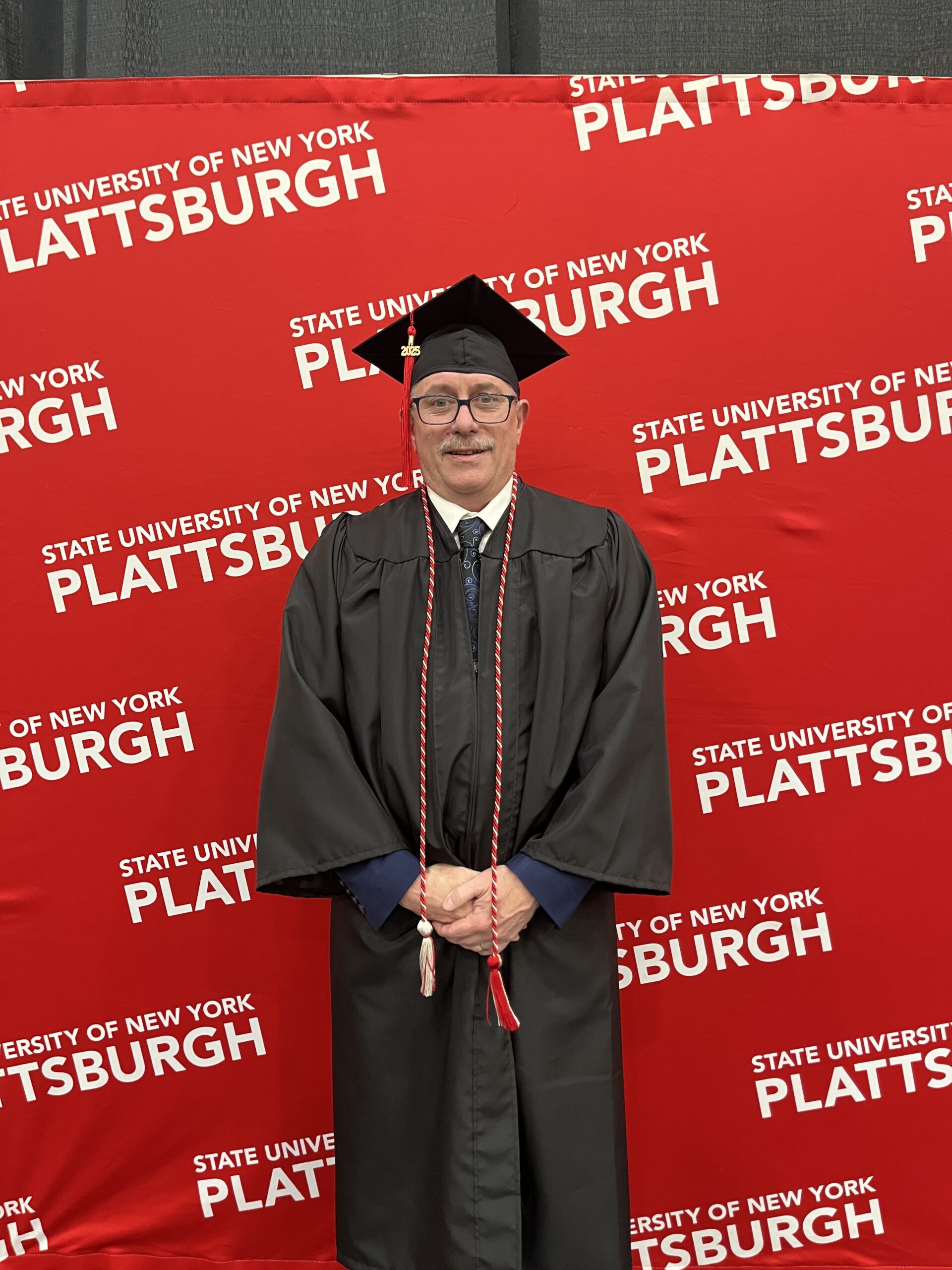 College graduate receiving diploma at commencement ceremony in Plattsburgh